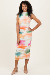 woman wearing a sleeveless floral print midi dress with colorful pastel hues and ruching details