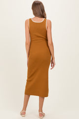 woman wearing a rust colored ribbed maternity dress with decorative trim on the neckline, shown from the back
