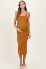 woman wearing a mustard ribbed maternity dress with a scoop neck and trim, gently holding her baby bump