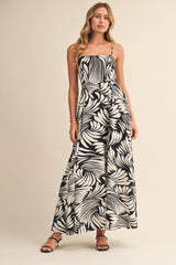 woman wearing a black and white floral print maxi dress with a fitted bodice and spaghetti straps
