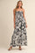 woman wearing a black and white floral print maxi dress with a fitted bodice and spaghetti straps