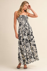 woman wearing a black and white floral maxi dress with spaghetti straps and a fitted bodice