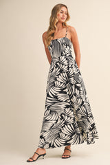 woman wearing a black and white floral print maxi dress with spaghetti straps and a flowy silhouette