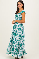 woman wearing a green floral print maxi dress with short sleeves and a smocked bodice, standing in profile
