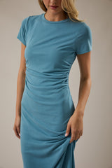 woman wearing a teal short sleeve fitted dress with ruching detail on the sides
