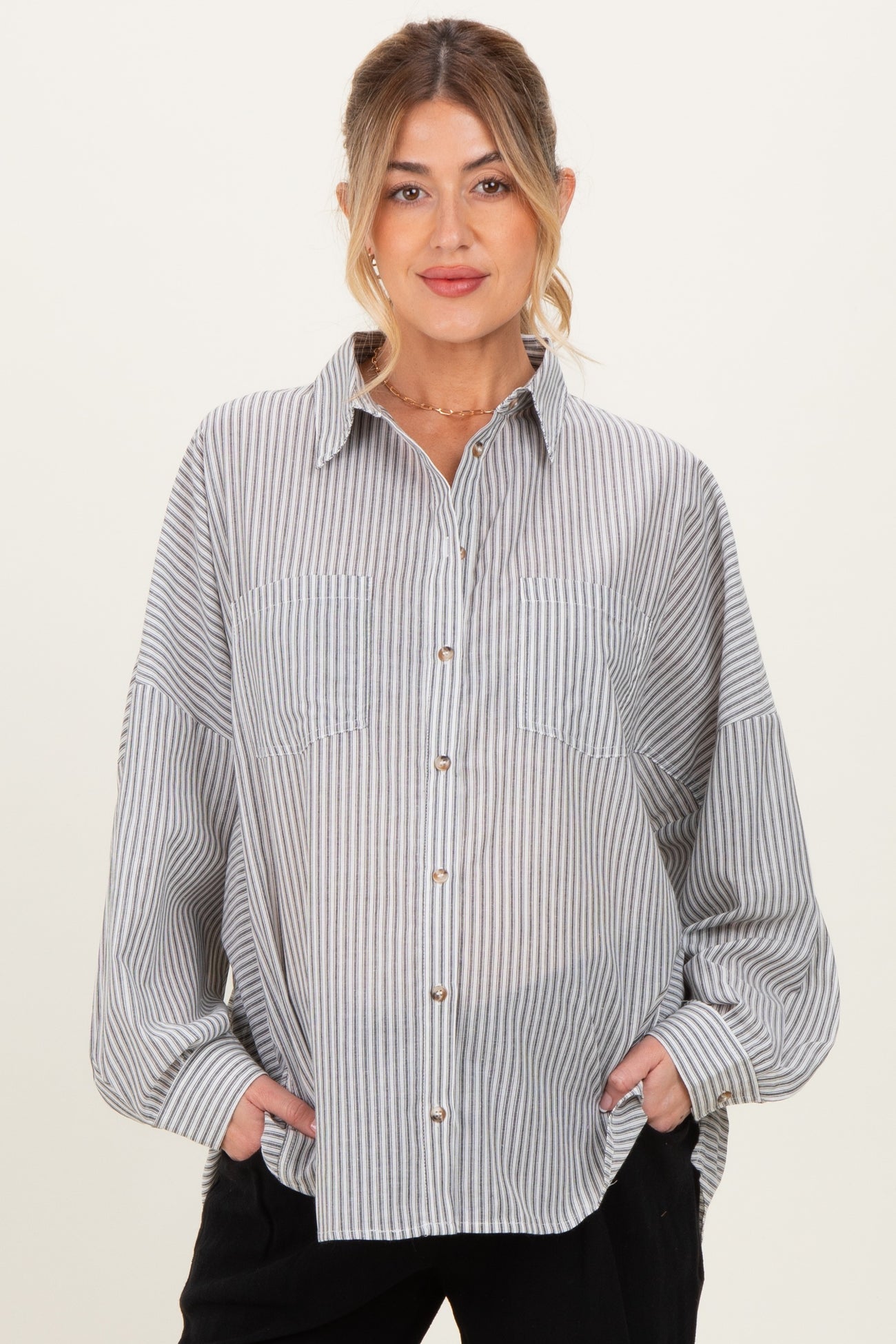 woman wearing a blue and white striped maternity button-up shirt with two front pockets and relaxed fit