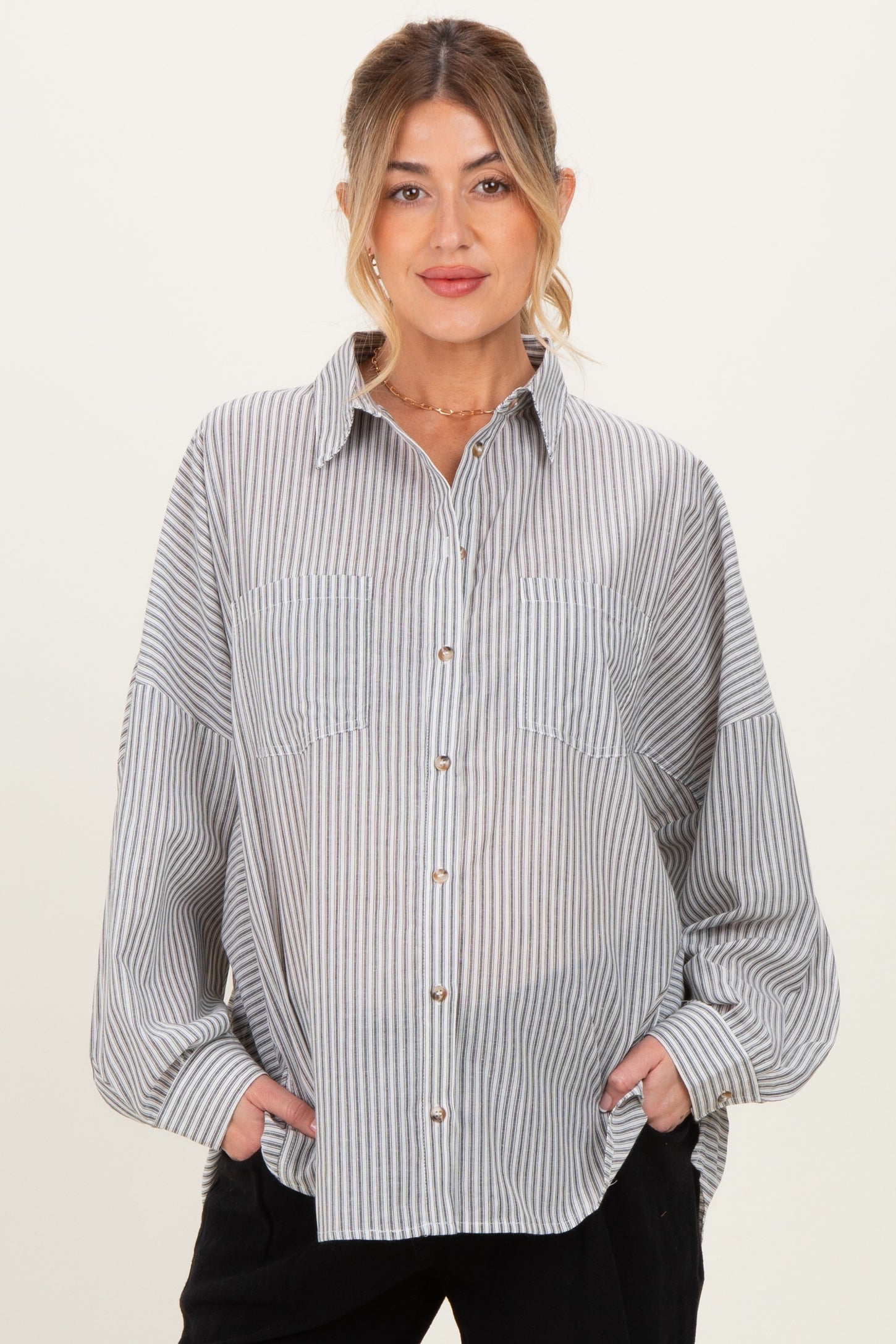 woman wearing a blue and white striped maternity button-up shirt with two front pockets and relaxed fit