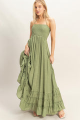 woman wearing a sage green strapless maxi dress with smocked bodice and ruffled hemline