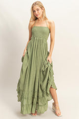 woman wearing a green smocked maxi dress with ruffle hem and side pockets