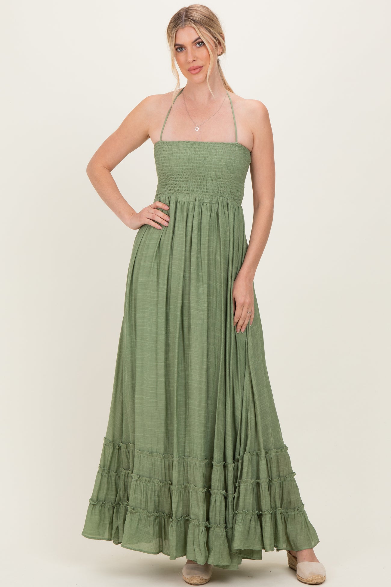 woman wearing a green strapless maxi dress with a smocked bodice and ruffled hem