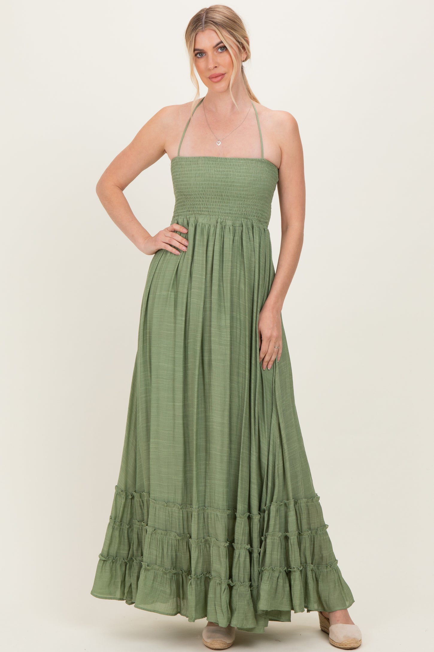 woman wearing a green strapless maxi dress with a smocked bodice and ruffled hem