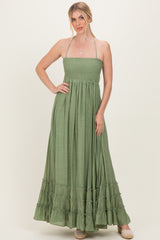 woman wearing a green strapless maxi dress with a smocked bodice and ruffled hem