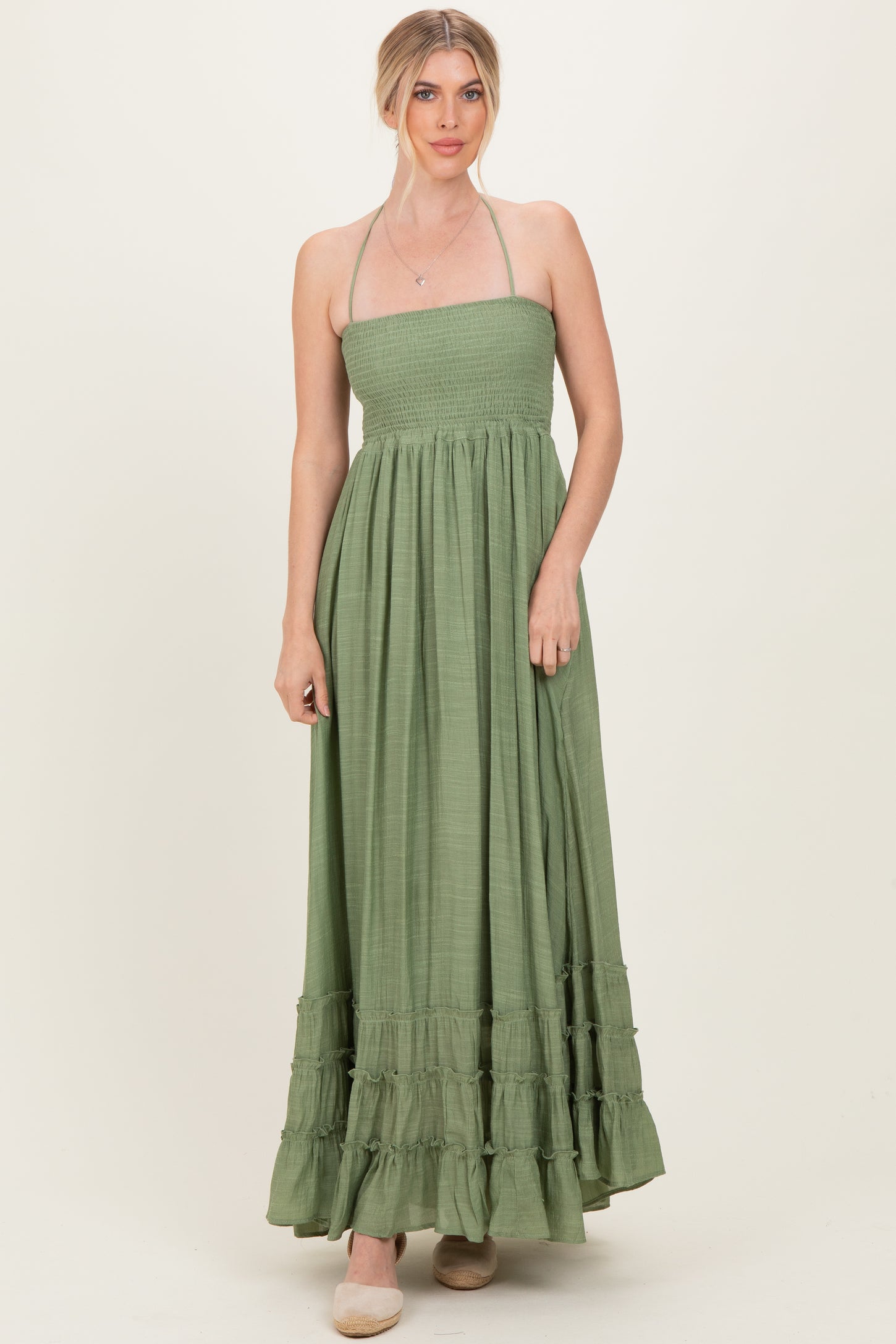woman wearing a green strapless maxi dress with a smocked bodice and ruffle hem