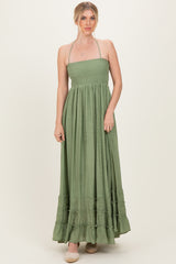 woman wearing a green strapless maxi dress with a smocked bodice and ruffle hem