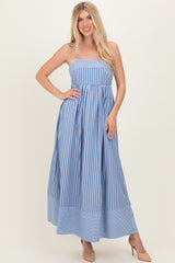 woman wearing a blue and white striped maxi dress with spaghetti straps and a flared skirt