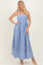 woman wearing a blue and white striped maxi dress with spaghetti straps and a flared skirt