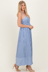woman wearing a blue and white striped maxi dress with spaghetti straps and a flowy silhouette