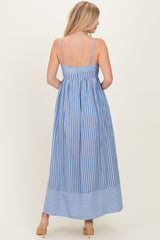 woman wearing a blue and white striped maxi dress with a fitted bodice and flowing skirt, viewed from the back