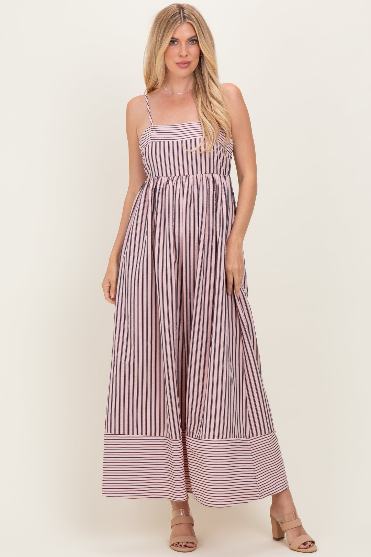 woman wearing a striped maxi dress with spaghetti straps and a cinched waist