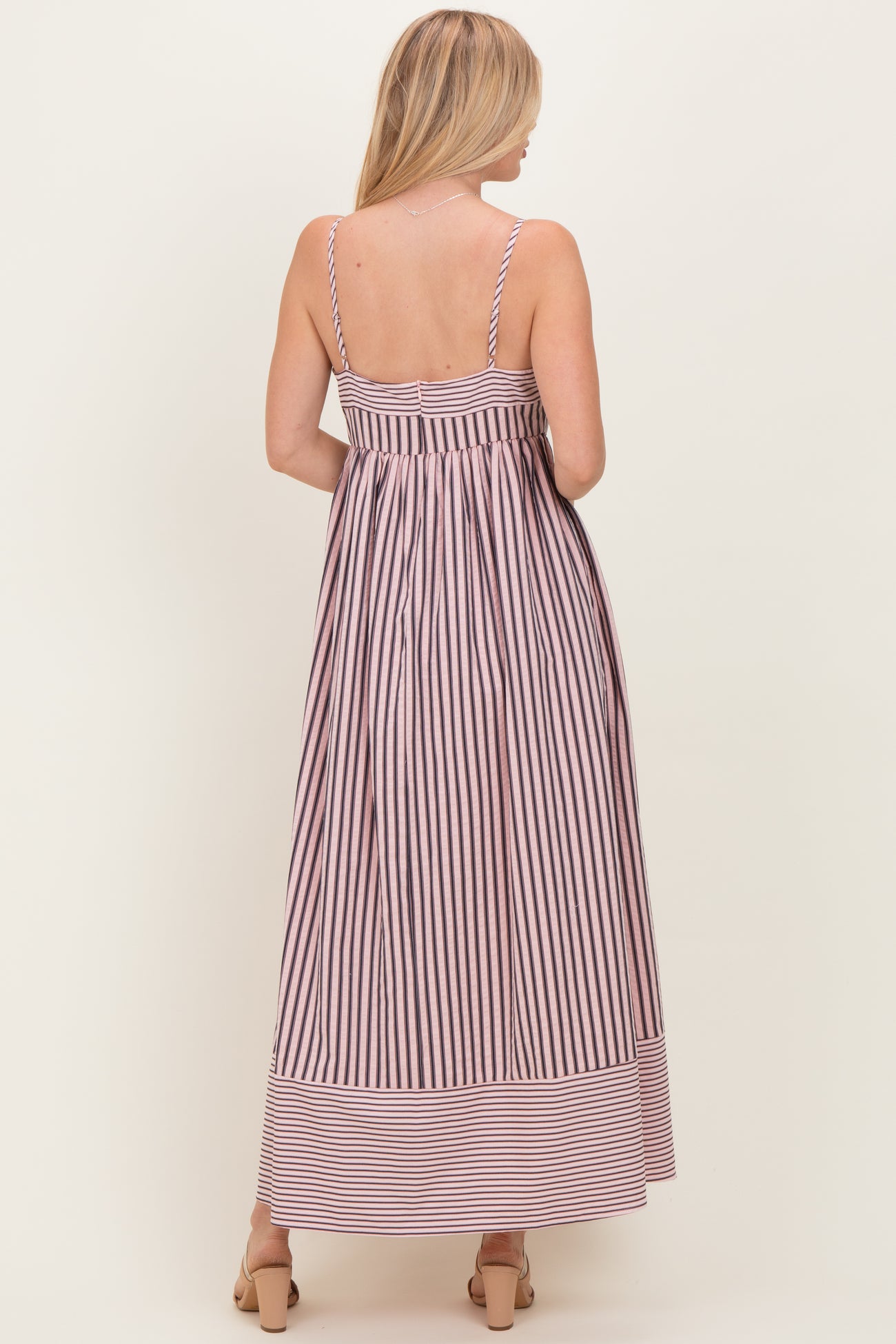 woman wearing a back view of a striped maxi dress with thin straps and a fitted bodice