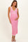 woman wearing a pink knitted maternity dress with white trim, holding her baby bump