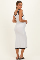 woman wearing a white maternity dress with black trim and a baby bump visible from the side