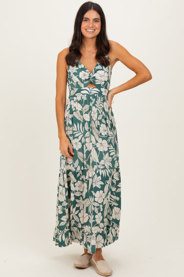 woman wearing a green floral maxi dress with a cut-out detail and a flowy skirt