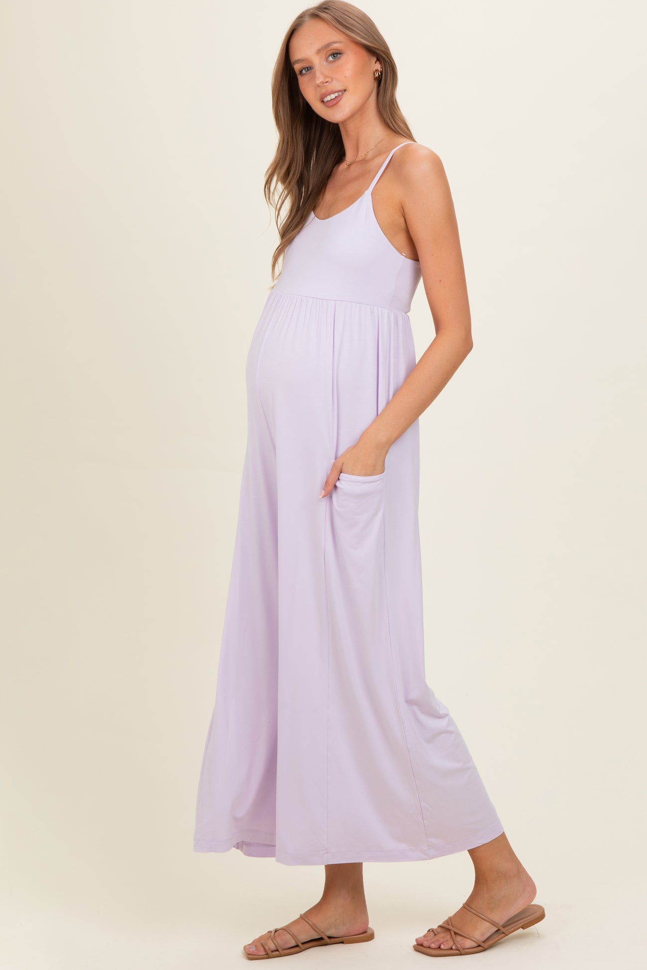 woman wearing a lavender maternity maxi dress with pockets and a visible baby bump