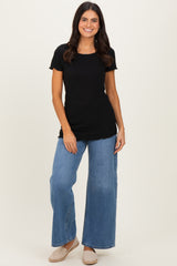 woman wearing a black ribbed short sleeve top and high-waisted wide leg blue jeans
