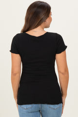 woman wearing a black short sleeve maternity top with a fitted silhouette and back scoop neckline