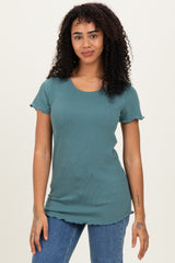 woman wearing a teal ribbed short sleeve top with scalloped edges and jeans