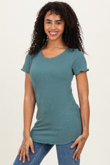 woman wearing a teal short sleeve ribbed top with a scoop neck and ruffle details, paired with blue jeans