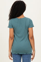 woman wearing a teal short sleeve top with a scalloped hem and back view, paired with blue jeans