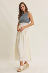 woman wearing a blue knitted sleeveless maxi dress with a white skirt and beige espadrille sandals