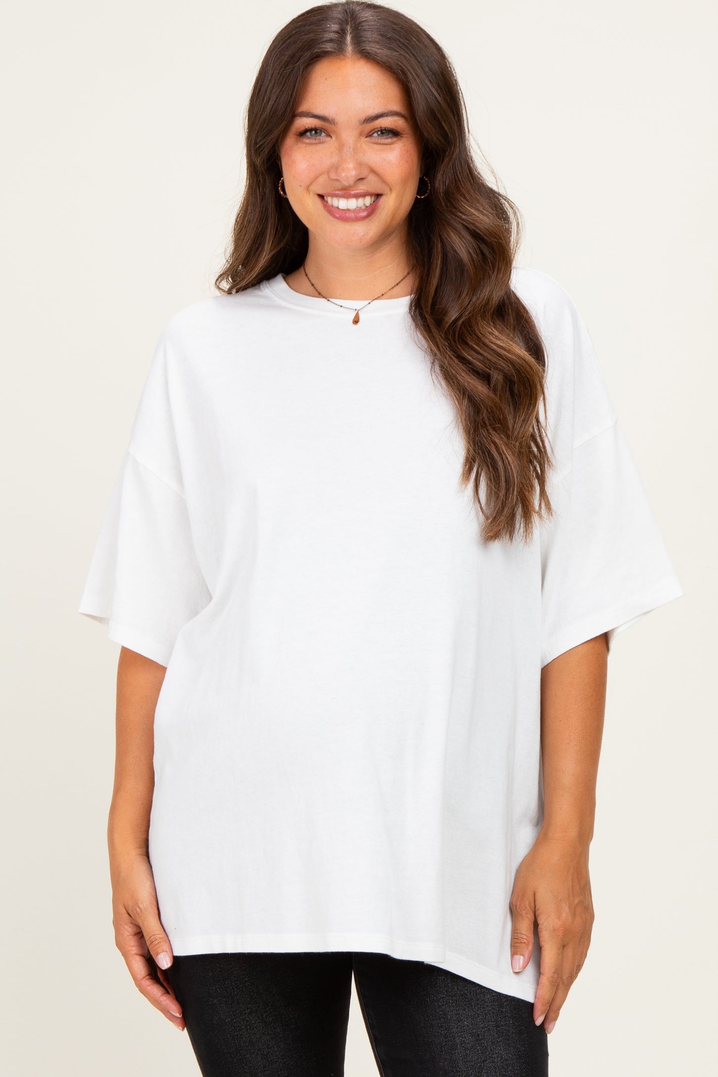 woman wearing a white oversized maternity t-shirt with short sleeves and a relaxed fit