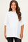 woman wearing a white oversized maternity t-shirt with short sleeves and a relaxed fit
