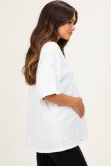 woman wearing a white oversized maternity t-shirt and holding her baby bump