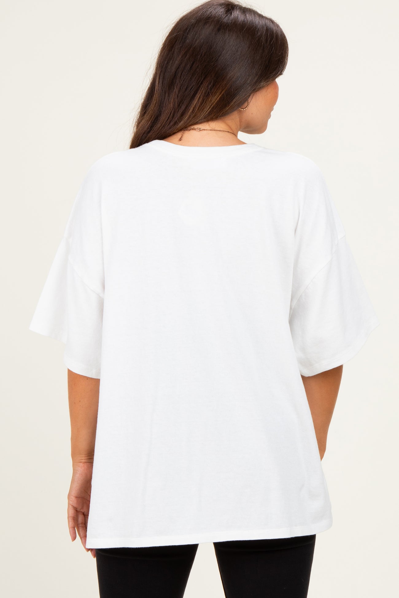 woman wearing a loose-fitting white maternity t-shirt, view from the back
