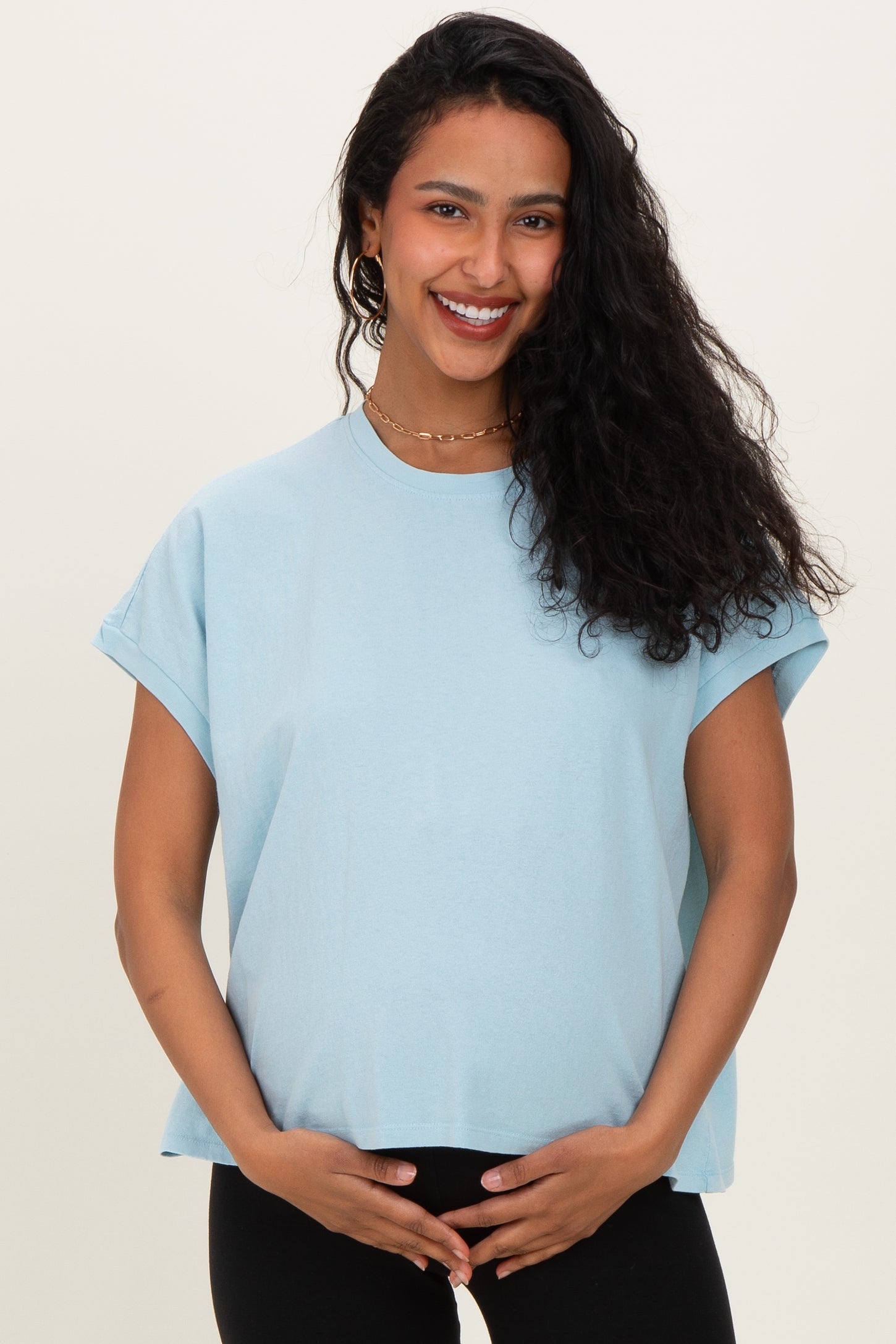 woman wearing a light blue maternity t-shirt and holding her baby bump