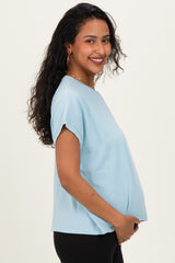 woman wearing a light blue maternity t-shirt and holding her baby bump