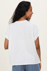 woman wearing a white short sleeve maternity top, showing the back view and styled with soft curls in her hair