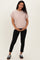 woman wearing a light pink maternity top and black pants, holding her baby bump