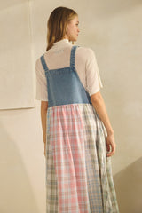 woman wearing a back view of a denim and plaid sundress with a long, flowing skirt in pastel colors