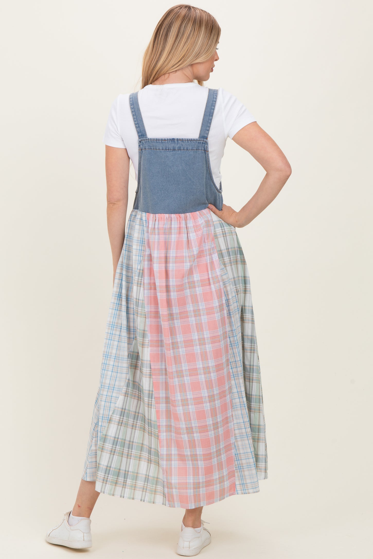 woman wearing a denim and plaid maxi dress with a fitted top and flared skirt, showcasing a mix of pastel colors