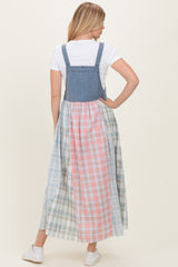 woman wearing a denim and plaid maxi dress with a fitted top and flared skirt, showcasing a mix of pastel colors