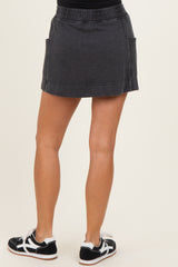 woman wearing a dark grey casual skirt with side pockets and a relaxed fit, paired with black and white sneakers