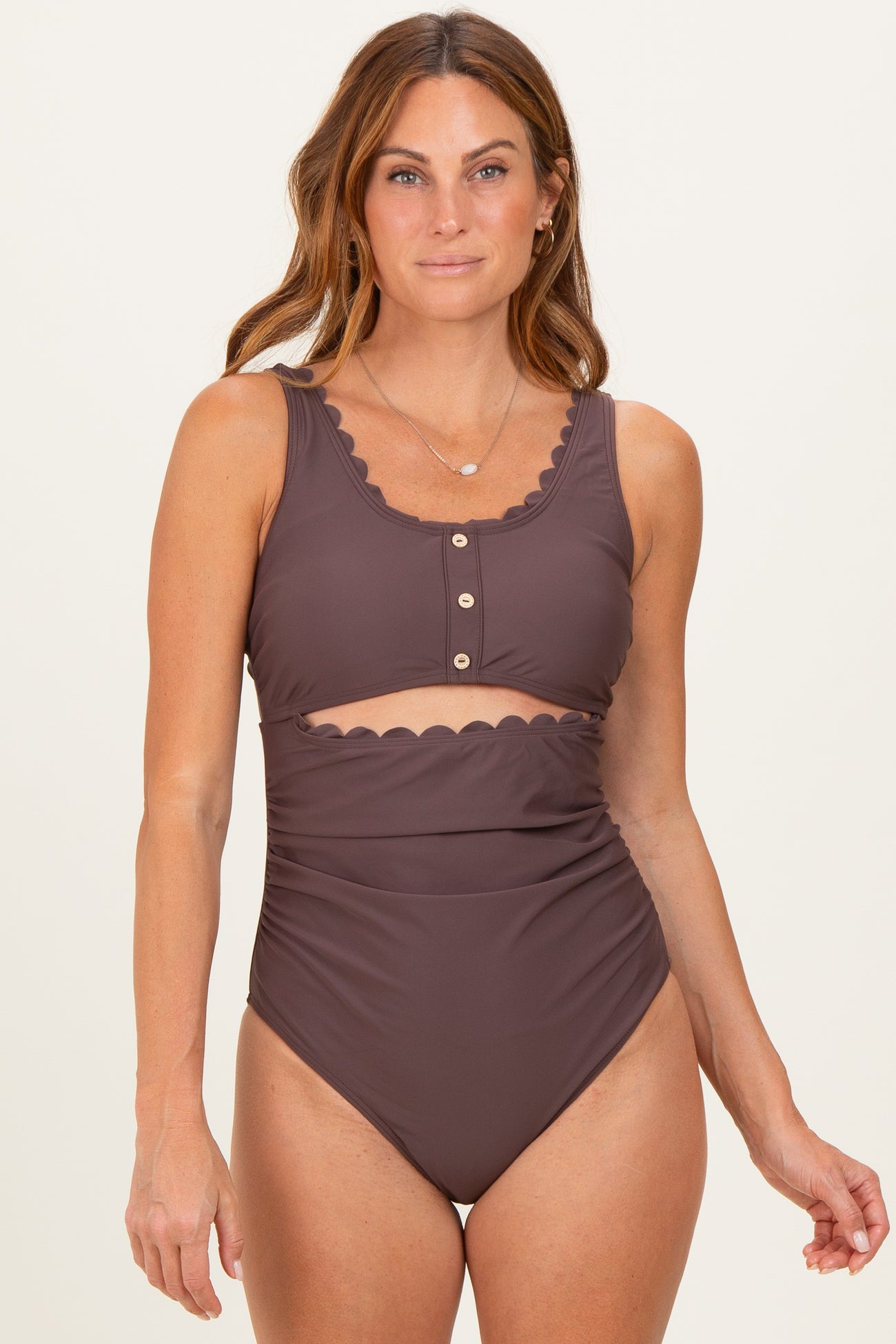 woman wearing a brown high-waisted bikini with scalloped details and button closures on the top