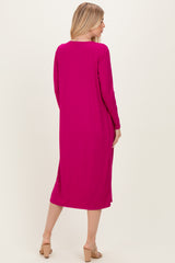 woman wearing a long sleeve bright pink ribbed dress, shown from the back