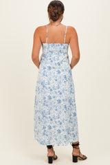 woman wearing a light blue floral maternity maxi dress with spaghetti straps and a flowy silhouette, showing her back