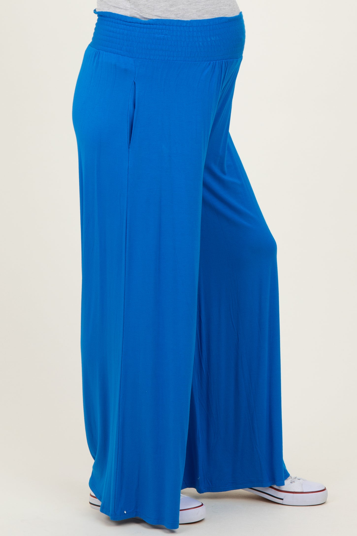 woman wearing bright blue maternity wide-leg pants with an elastic waistband and a pregnancy belly visible